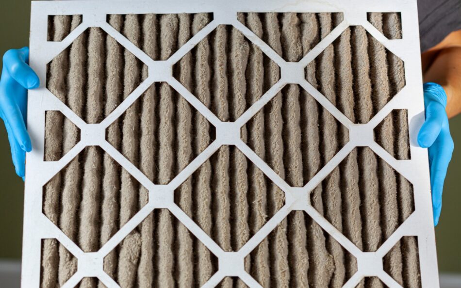 Close-up of clogged HVAC air filter with heavy dust buildup